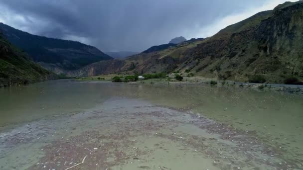 Garrafas de plástico em uma água poluída do rio. Lixo diverso em um rio de montanha. Contaminação do ambiente. Problemas ecológicos e ameaças de extinção. Vista aérea, vista drone . — Vídeo de Stock