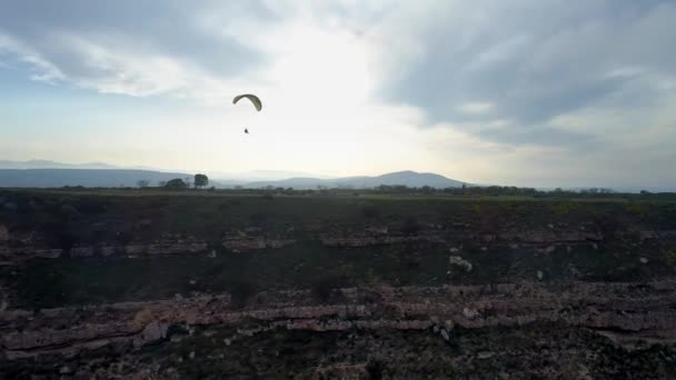 Gleitschirmflieger fliegen während des Extremsportwettbewerbs Gleitschirmfliegen über atemberaubende Bergketten. Gleitschirme fliegen bei Sonnenuntergang in den Bergen — Stockvideo