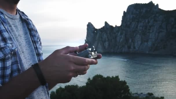 Drone Uzaktan Kumanda, Bir drone pilot operatörünün el ve uzaktan görünümü. Genç adam yolculukta sahile yakın drone kontrol eder. Deniz in ve dağların güzel bir manzarasına sahiptir — Stok video