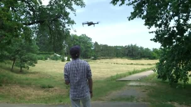 Hexacopter-Drohne landet auf den Händen. Ein junger Mann steuert eine Drohne in der Nähe des Meeres. einen Hubschrauber in der Hand, landet — Stockvideo