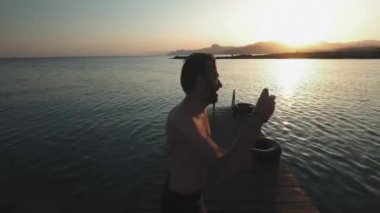 Genç milenyal otantik hipster adam muhteşem doğal c, temiz taze kelime ile dağ alp Gölü ahşap tahta üzerinde hızlı çalışır. komik bomba şekilde atlar. Yaz gezisi zevk alır.