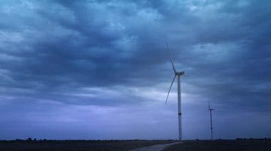 Rüzgar türbinleri çevresel enerji üretir. Çevre kirliliği kavramı, alternatif enerjinin yeni teknolojileri. Genel plan, akşam, bulutlu.