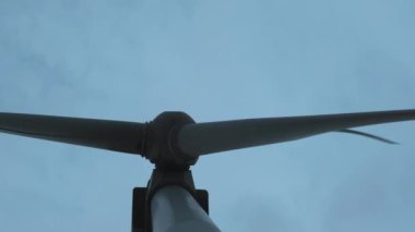 Yakın çekim: Rüzgar türbinleri çevresel enerji üretir. Çevre kirliliği kavramı, alternatif enerjinin yeni teknolojileri. Genel plan, akşam, bulutlu.