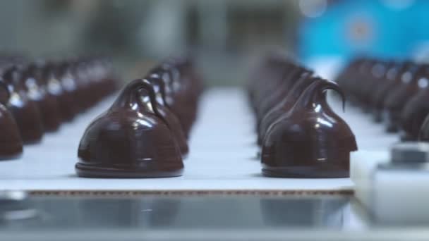 Chocolade snoep bars productie-proces van de voedingsindustrie. Veel chocolaatjes op de productielijn — Stockvideo