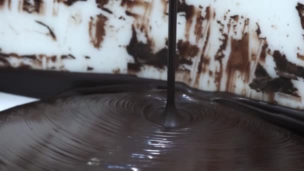 巧克力。浇注融化的液体优质黑巧克力。熔融液体热巧克力漩涡的特写。糖果。糖果店准备甜点，结冰 — 图库视频影像