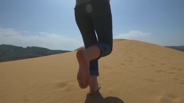 ผู้หญิงวิ่งไปตามทรายในทะเลทราย ผู้หญิงคนหนึ่งวิ่งเท้าเปล่าบนเนินทรายในทราย . — วีดีโอสต็อก