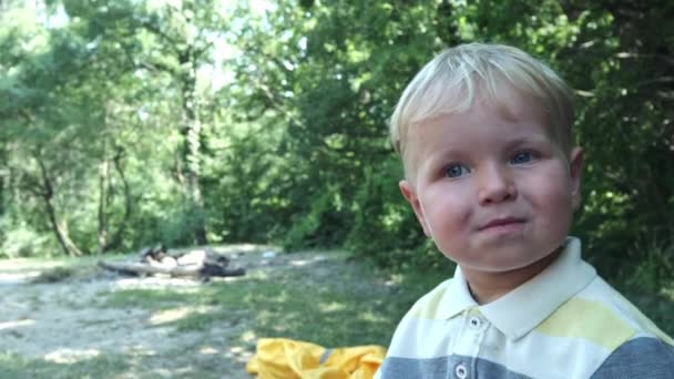 Visage perdu d'un petit garçon aux cheveux blonds portant des lunettes de soleil. Portrait de bébé joyeux dans de grandes lunettes de soleil . — Video