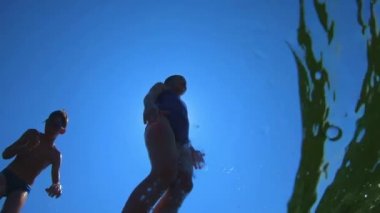 Genç Yakışıklı Çocuk Denize Atlıyor. Çocuklar taklaların denizine atlarlar. Gençler suya atlar. Suyun altında yüz ve oyna. Denizde yaz eğlencesi