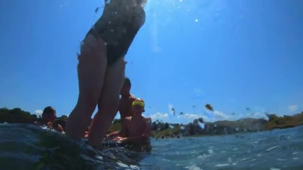 Joven chico guapo saltando al mar. Los niños saltan al mar de saltos mortales. Los adolescentes saltan al agua. Nadar bajo el agua y jugar. Diversión de verano en el mar — Vídeos de Stock