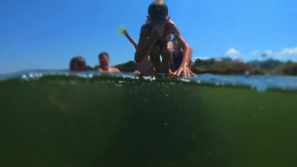 Ein hübscher Junge springt ans Meer. Kinder springen ins Meer der Purzelbäume. Teenager springen ins Wasser. unter Wasser schwimmen und spielen. Sommerspaß auf See — Stockvideo
