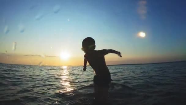 Rapaz bonito a saltar para o mar. As crianças saltam no mar de cambalhotas. Os adolescentes saltam para a água. Nade debaixo de água e brinque. Diversão de verão no mar — Vídeo de Stock