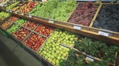 Raflarda mağazabirçok farklı meyve. Raflar boyunca kamera açıklıkları.