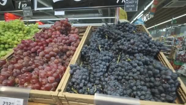 Many bunches of grapes lie on shelves in a supermarket. — Stock Video