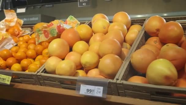 Spousta pomerančů a citrusových plodů. V supermarketu leží spousta plodů, v rozsahu kamery. — Stock video