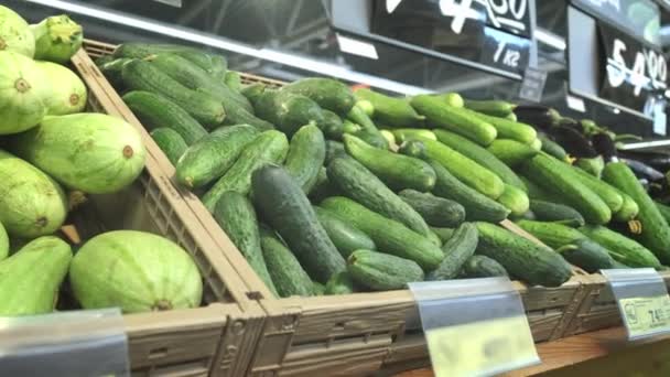 Muchas verduras diferentes en los estantes del supermercado. Pepinos, col, rábanos, tomates . — Vídeos de Stock