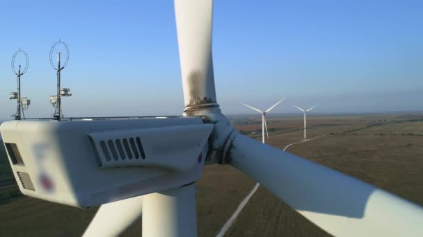 Großaufnahme einer Windkraftanlage. Windkraftanlage von oben, die sich über der weißen modernen Konstruktion der Windkraftanlage bewegt, ist ein Gerät, das kinetische Windenergie in elektrische Energie umwandelt — Stockvideo