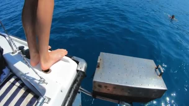 Beau jeune homme sautant d'un bateau ou d'un yacht dans la mer ou l'océan. Vacances d'été avec des amis. Les touristes s'amusent et plongent. Mouvement lent — Video