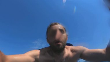 Yakışıklı genç adam bir tekne veya yattan denize ya da okyanusa atlıyor. Arkadaşlarıyla yaz tatili. Turistler eğlenir ve dalın. Yavaş çekim