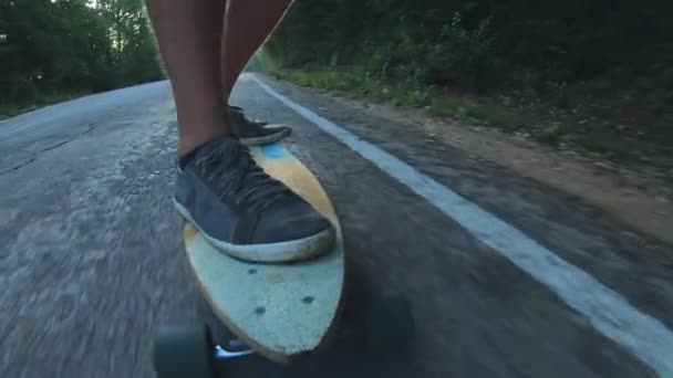 Close-up skateboarder jongen rijden buiten. Een jonge man rijdt een Longboard op de snelweg. Misty Road in het bos — Stockvideo