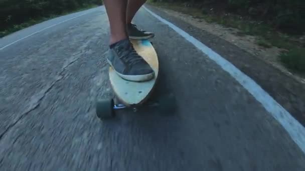 特写滑板男孩在户外骑行。一个年轻人在公路上骑着一块长板。森林中的迷雾路 — 图库视频影像