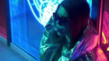 Kürk gözlük genç moda genç kız sokak neon mavi pembe işareti ile aydınlatılmış sakız üfleme, trendy gece ışık güzel bin yıllık kadın 80s kavramı geri kızdırma