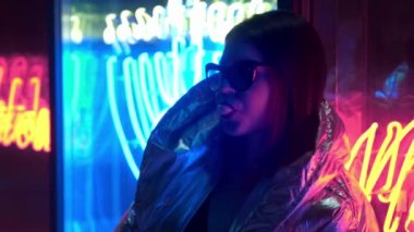 Kürk gözlük genç moda genç kız sokak neon mavi pembe işareti ile aydınlatılmış sakız üfleme, trendy gece ışık güzel bin yıllık kadın 80s kavramı geri kızdırma