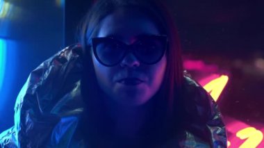 Kürk gözlük genç moda genç kız sokak neon mavi pembe işareti ile aydınlatılmış sakız üfleme, trendy gece ışık güzel bin yıllık kadın 80s kavramı geri kızdırma