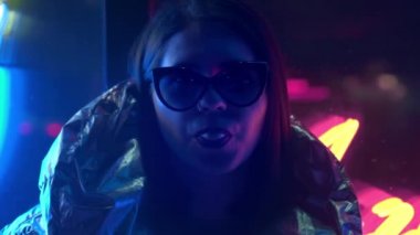 Kürk gözlük genç moda genç kız sokak neon mavi pembe işareti ile aydınlatılmış sakız üfleme, trendy gece ışık güzel bin yıllık kadın 80s kavramı geri kızdırma