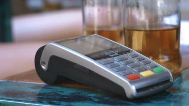 NFC kredi kartı ödemesi. Müşterinin erkek eli NFC teknolojisiyle temassız kredi kartıyla ödeme yapıyor. Elektronik paranın banka hizmetleri. Kablosuz para transferi. Kablosuz ödeme