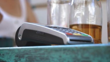 NFC kredi kartı ödemesi. Müşterinin erkek eli NFC teknolojisiyle temassız kredi kartıyla ödeme yapıyor. Elektronik paranın banka hizmetleri. Kablosuz para transferi. Kablosuz ödeme