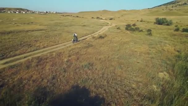 AÉRIAL : motocycliste chevauche sur le sol sablonneux dans le désert. Sports extrêmes dans des endroits pittoresques. Motocross dans le désert . — Video