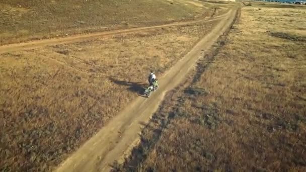 空中:オートバイのライダーは、砂漠の砂地に乗ります。絵のように美しい場所で極端なスポーツ。砂漠のモトクロス. — ストック動画
