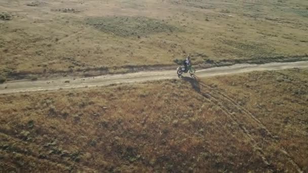 AEREO: motociclista cavalca sul terreno sabbioso nel deserto. Sport estremi in luoghi pittoreschi. Motocross nel deserto . — Video Stock