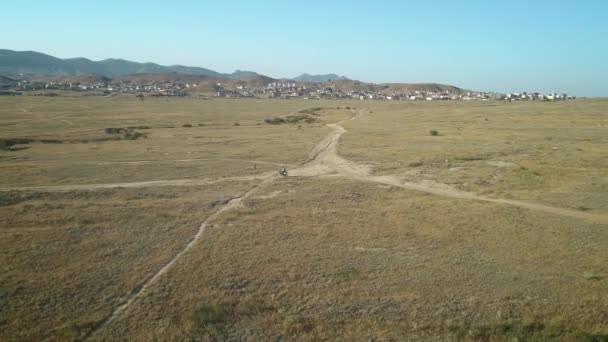 AÉRIAL : motocycliste chevauche sur le sol sablonneux dans le désert. Sports extrêmes dans des endroits pittoresques. Motocross dans le désert . — Video