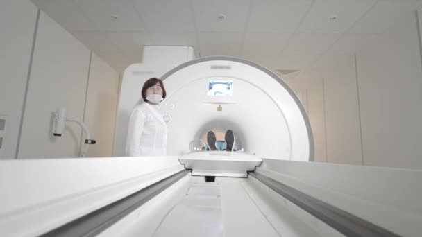 의사는 진료소에서 환자를 위해 MRI 촬영을 한다. 여자 애가 MRI 기계에 누워 있어요. 인간의 몸을 연구하는 자기 공명 영상. 현대 의학 기술 — 비디오