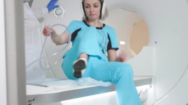 Doktor klinikteki bir hasta için MRI taraması yapıyor. Kız MRI cihazında yatıyor. İnsan vücudu çalışmasında manyetik rezonans görüntüleme. Tıptaki modern teknolojiler