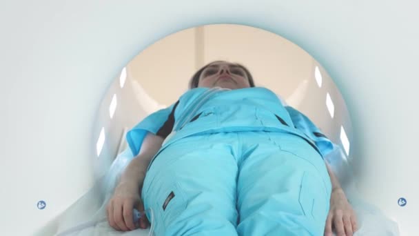 El médico realiza una resonancia magnética para un paciente en la clínica. La chica yace en el dispositivo de resonancia magnética. Imágenes por resonancia magnética en el estudio del cuerpo humano. Tecnologías modernas en medicina — Vídeo de stock