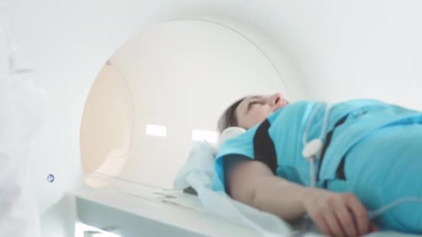 Doktor klinikteki bir hasta için MRI taraması yapıyor. Kız MRI cihazında yatıyor. İnsan vücudu çalışmasında manyetik rezonans görüntüleme. Tıptaki modern teknolojiler — Stok video