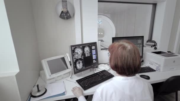 Il medico tecnico controlla una risonanza magnetica. Risonanza magnetica imaging nello studio del corpo umano. Lo specialista sta guardando il monitor in laboratorio — Video Stock