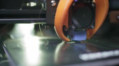 3D yazıcı, plastik karın kaslarından soyut bir küp şeklinde basıyor. 3D yazıcı başı devrede. Otomatik üç boyutlu bir 3D yazıcı plastik işlevi görür. Makro.