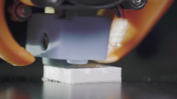 A 3D-s nyomtató egy absztrakt kocka alakú kockát nyomtat fehér kocka alakú műanyagból. 3D nyomtatófej akció közben. Egy automatikus háromdimenziós 3D-s nyomtató műanyagot végez. Makró. — Stock videók
