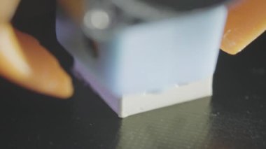 3D yazıcı, plastik karın kaslarından soyut bir küp şeklinde basıyor. 3D yazıcı başı devrede. Otomatik üç boyutlu bir 3D yazıcı plastik işlevi görür. Makro.