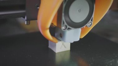 3D yazıcı beyaz karın kaslarından soyut bir kübik figür basıyor. 3D baskı makinesinin iğnesi plastiğe uygulanır. Otomatik üç boyutlu 3D yazıcı plastik gerçekleştirir