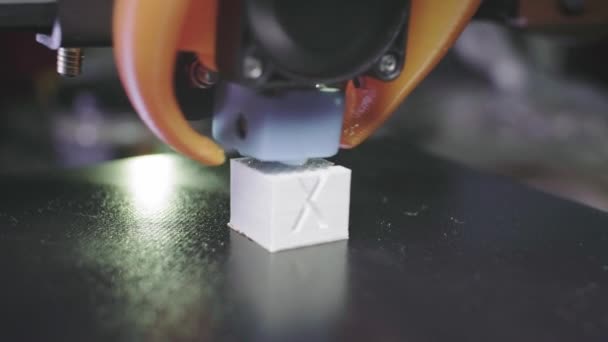 Der 3D-Drucker druckt eine abstrakte kubische Figur aus weißem Kunststoff. Die Nadel der 3D-Druckmaschine trägt Plastik auf. Automatischer dreidimensionaler 3D-Drucker für Kunststoff — Stockvideo