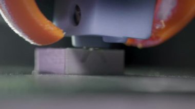 3D yazıcı, plastik karın kaslarından soyut bir küp şeklinde basıyor. 3D yazıcı başı devrede. Otomatik üç boyutlu bir 3D yazıcı plastik işlevi görür. Makro.