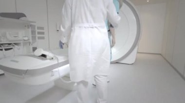 Doktor klinikte bir hasta için MRI taraması yapar. Kız MRI cihazında yatıyor. İnsan vücudu çalışmasında manyetik rezonans görüntüleme. Tıptaki modern teknolojiler. Ciğerleri inceler.