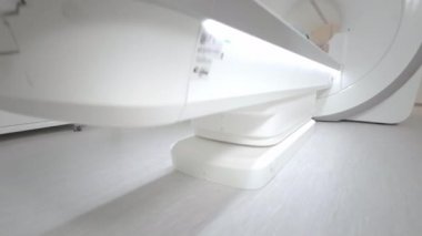Doktor klinikteki bir hasta için MRI taraması yapıyor. Kız MRI cihazında yatıyor. İnsan vücudu çalışmasında manyetik rezonans görüntüleme. Tıptaki modern teknolojiler