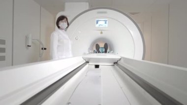 Doktor klinikte bir hasta için MRI taraması yapar. Kız MRI cihazında yatıyor. İnsan vücudu çalışmasında manyetik rezonans görüntüleme. Tıptaki modern teknolojiler. Ciğerleri inceler.