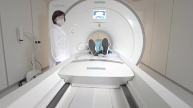 Doktor klinikte bir hasta için MRI taraması yapar. Kız MRI cihazında yatıyor. İnsan vücudu çalışmasında manyetik rezonans görüntüleme. Tıptaki modern teknolojiler. Ciğerleri inceler.