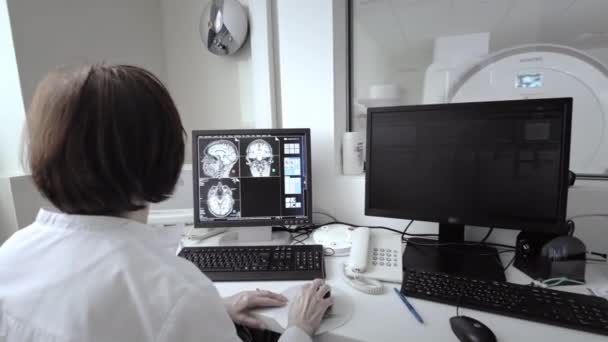 Concept futuriste : En laboratoire médical, le chirurgien portant un casque de réalité virtuelle utilise des contrôleurs pour opérer à distance le patient avec un robot médical. Progrès technologiques de pointe en médecine. — Video